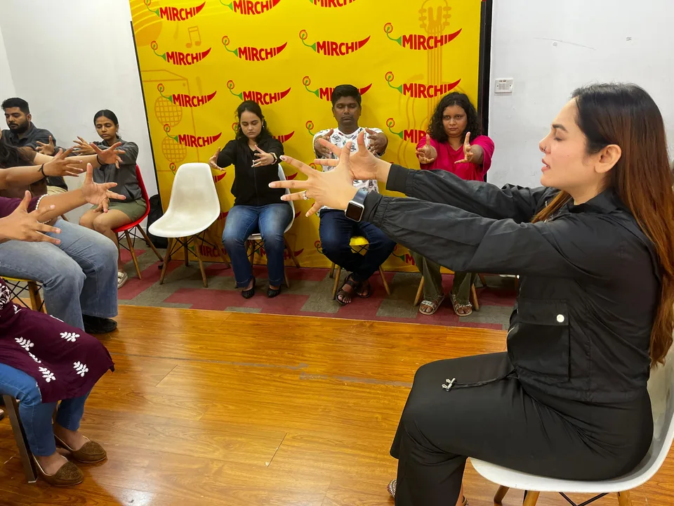 Vibha Jain seated in front of a group of workshop participants, guiding a focused-attention exercise.